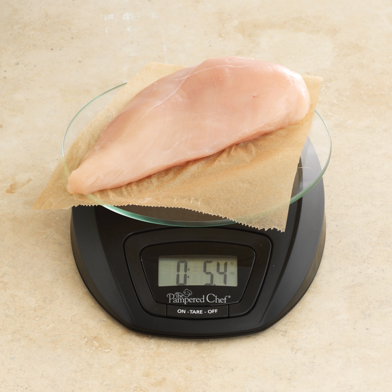 Kitchen scale measuring chicken breast.